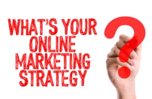 Hand with marker writing: Whats Your Online Marketing Strategy?